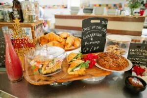 Bakery display with pastries and cake sign.