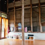 Rustic yoga studio with wooden beams and mats.